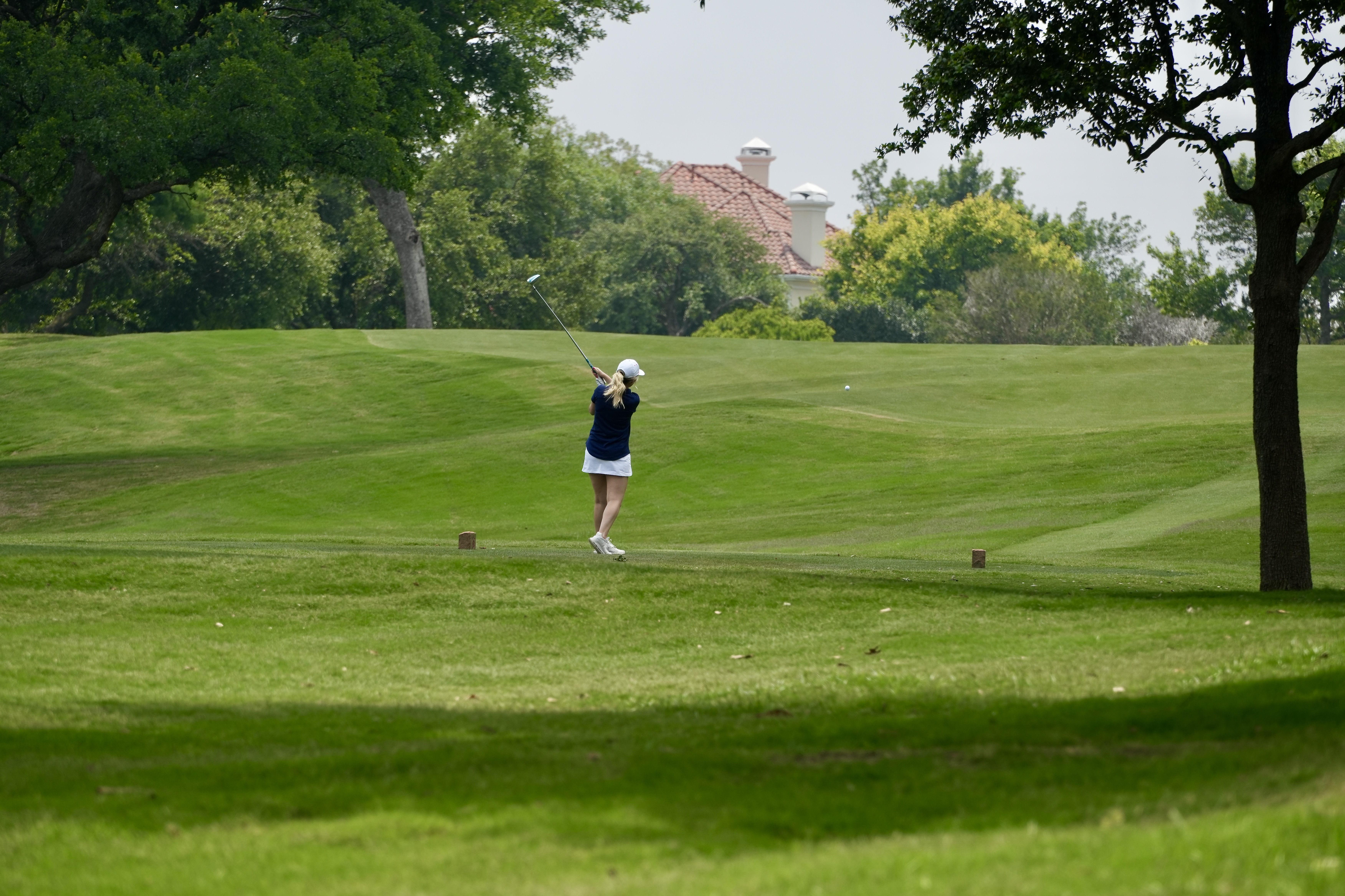 A woman swinging a golf club
